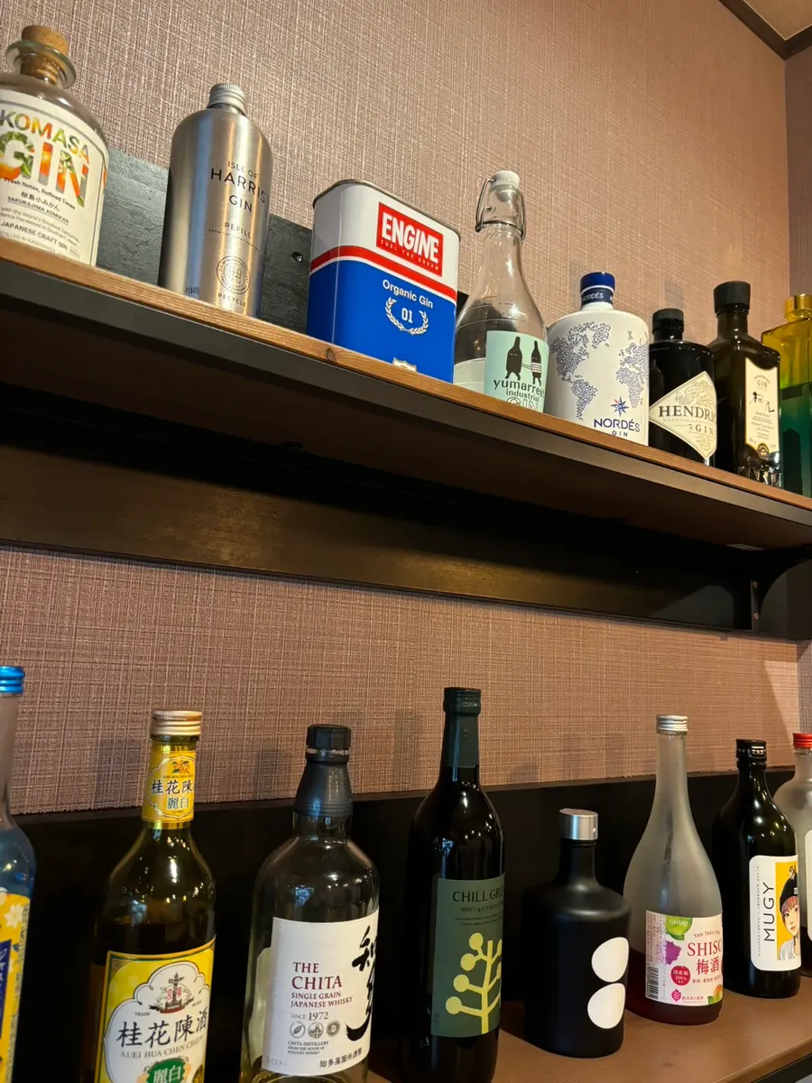 店内の棚。上段にジンが並び、下段に桂花陳酒・ウイスキー・梅酒などが置かれている
